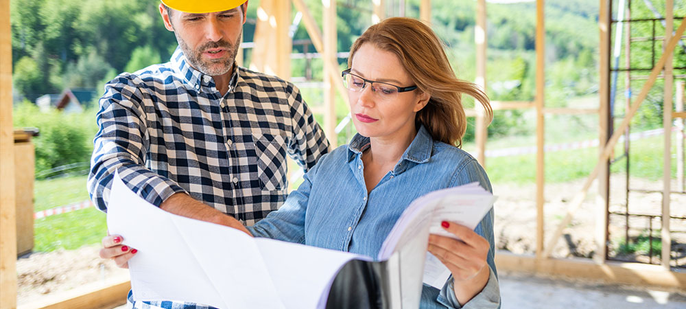 woman talking with builder at home build site.